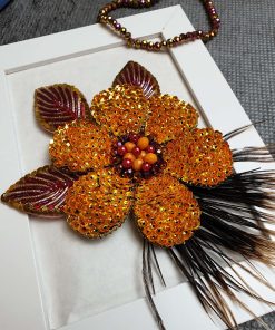 گل تزیینی دست‌ساز نارنجی با منجوق‌دوزی و پرهای طبیعی