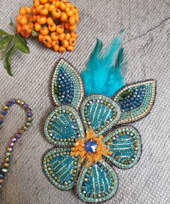 پنل لباس جواهردوزی دست‌دوز طرح گل فیروزه‌ای و طلایی با پرهای آبی