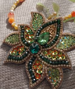 سنجاق سینه جواهردوزی دست‌دوز با طرح گل و سنگ‌های سبز و طلایی – اکسسوری زنانه لوکس و درخشان