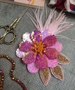 پنل لباس جواهردوزی دست‌دوز طرح گل صورتیی و طلایی با پرهای صورتی